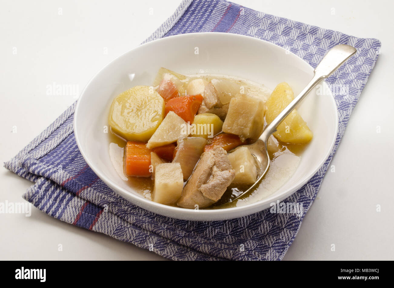 Clásico estofado irlandés con una cuchara y un plato hondo con vegetales growen inicio Foto de stock