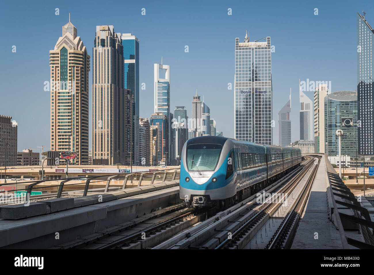 Un tren del Metro de Dubai y el centro de torres de oficinas en Dujbai, EAU, Oriente Medio. Foto de stock