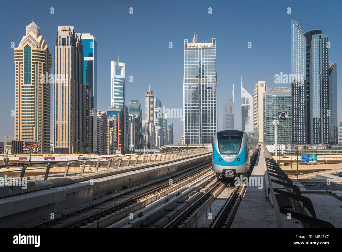 Un tren del Metro de Dubai y el centro de torres de oficinas en Dujbai, EAU, Oriente Medio. Foto de stock