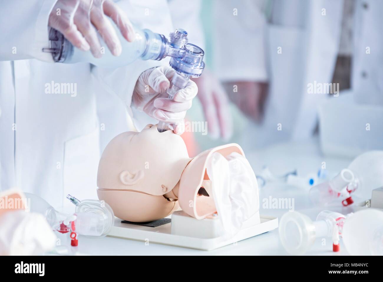 Los médicos que practican la intubación traqueal en un maniquí de formación infantil. Foto de stock