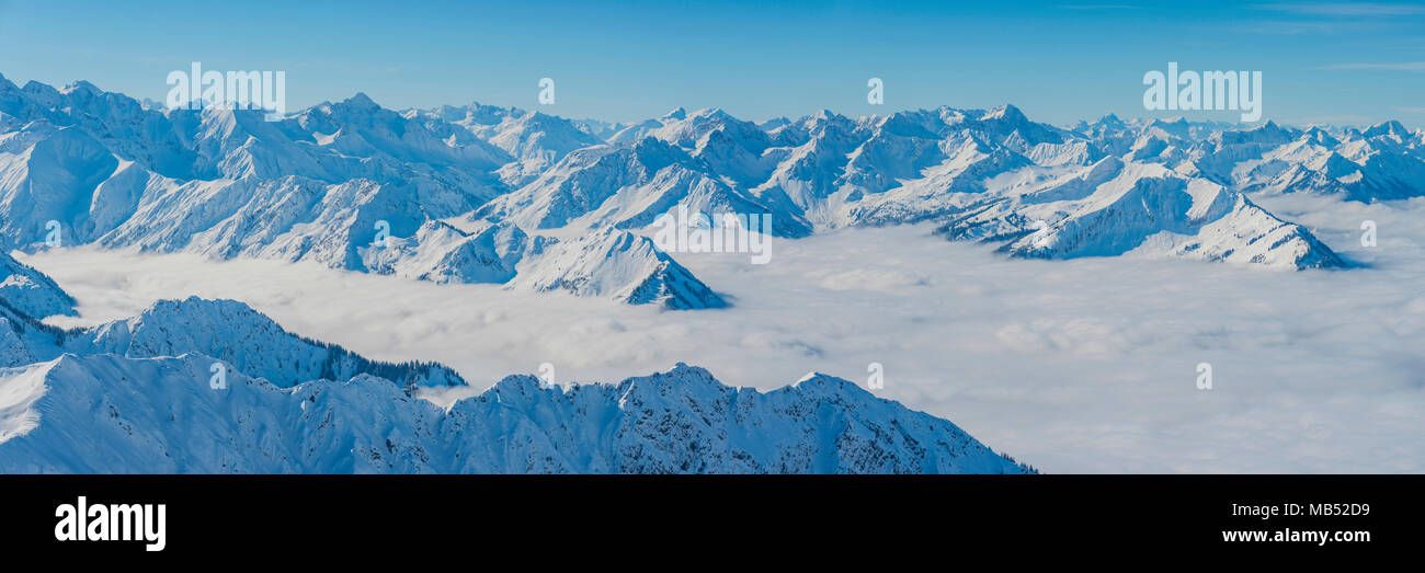 Panorámica de la montaña en invierno, picos montañosos nevados que se elevan por encima de las nubes, vista desde el Nebelhorn, 2224m, Allgäu Alpes Allgäu. Foto de stock