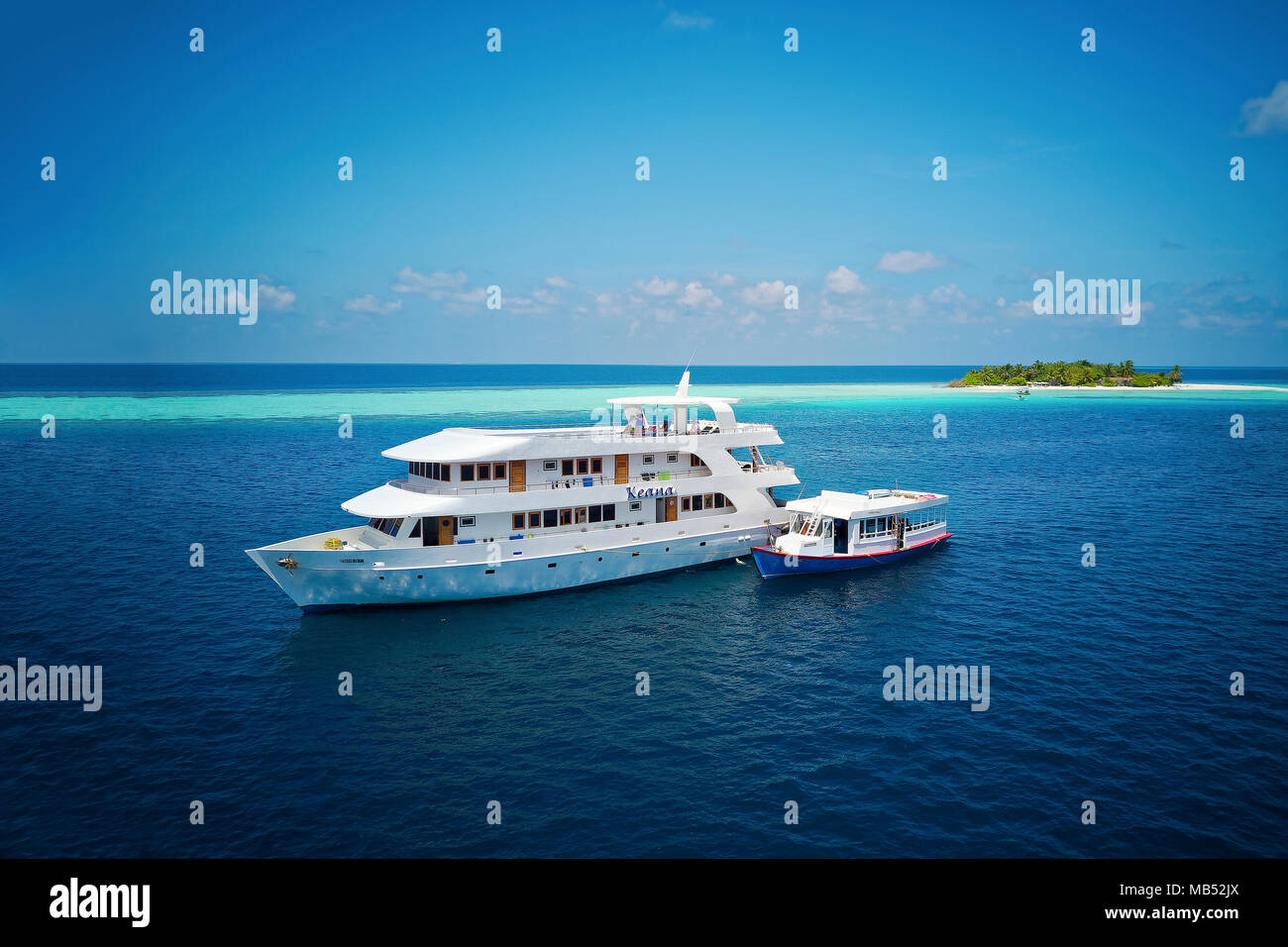 Safari de buceo barco MS Keana dhoni de buceo esté anclado en una deshabitada isla con palmeras, Ari Atoll, Maldivas, Océano Índico Foto de stock
