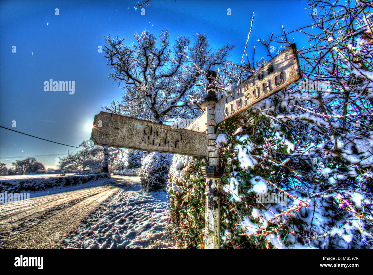 Aldea de Coddington, Inglaterra. Visión artística de un cubierto de nieve rural pre Worboys dirección firmar, en la zona rural de Cheshire. Foto de stock