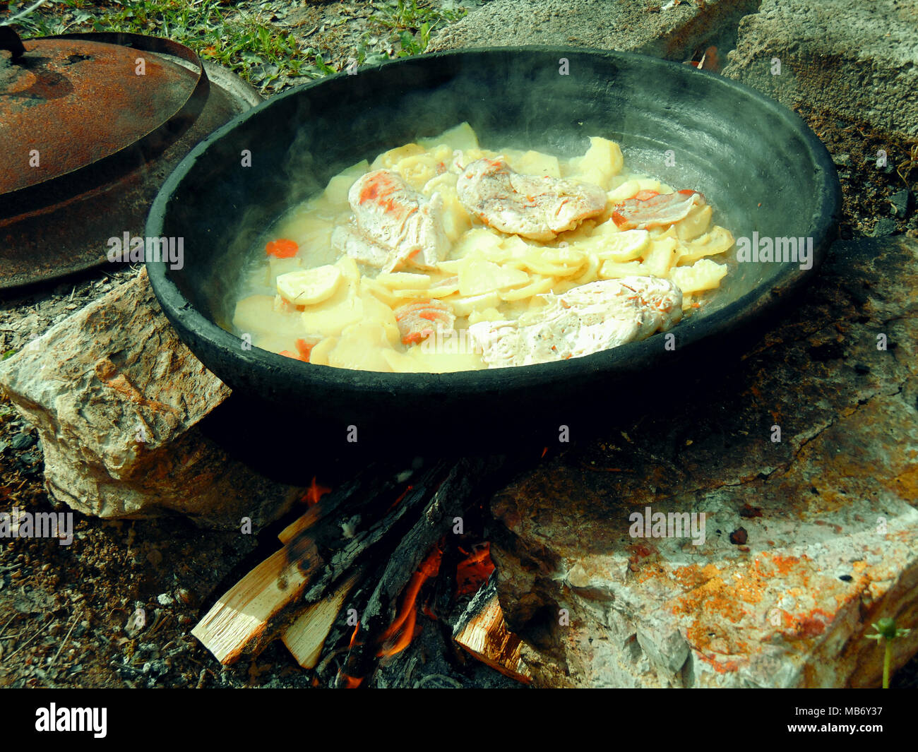 Cocinar en forma tradicional en fuego de leña relajante día fuera Foto de stock