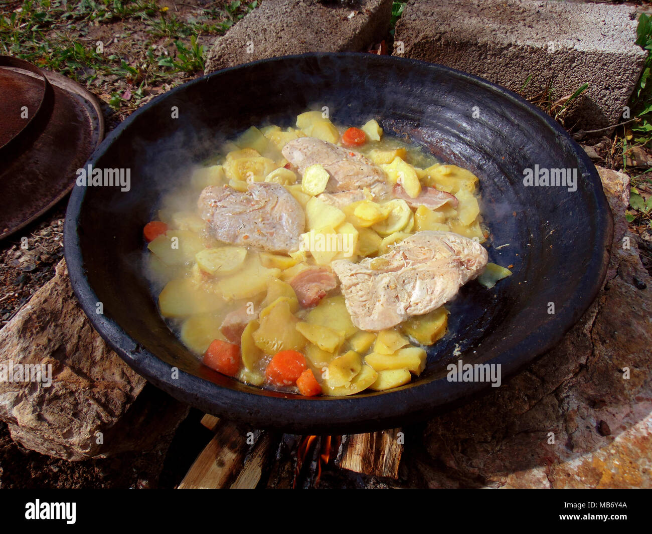 Cocinar en forma tradicional en fuego de leña relajante día fuera Foto de stock
