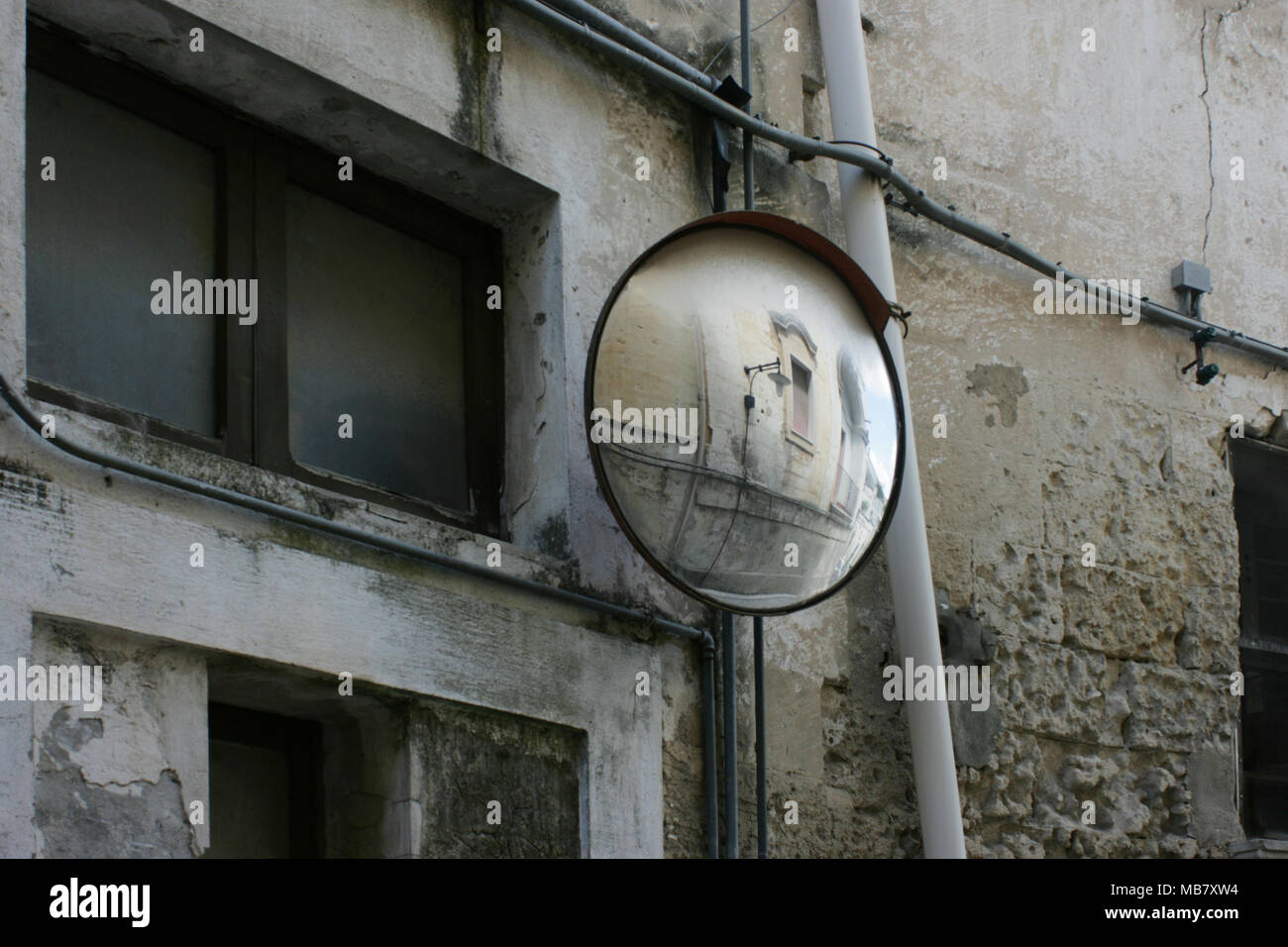Un detalle arquitectónico y espejos en vista del lado opuesto de la calle se muestra en un punto ciego espejo. Matera, Italia Foto de stock
