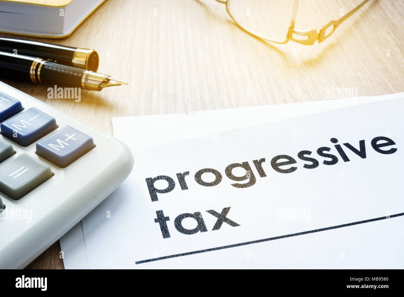 Artículos sobre impuestos progresivos sobre un escritorio de oficina. Foto de stock