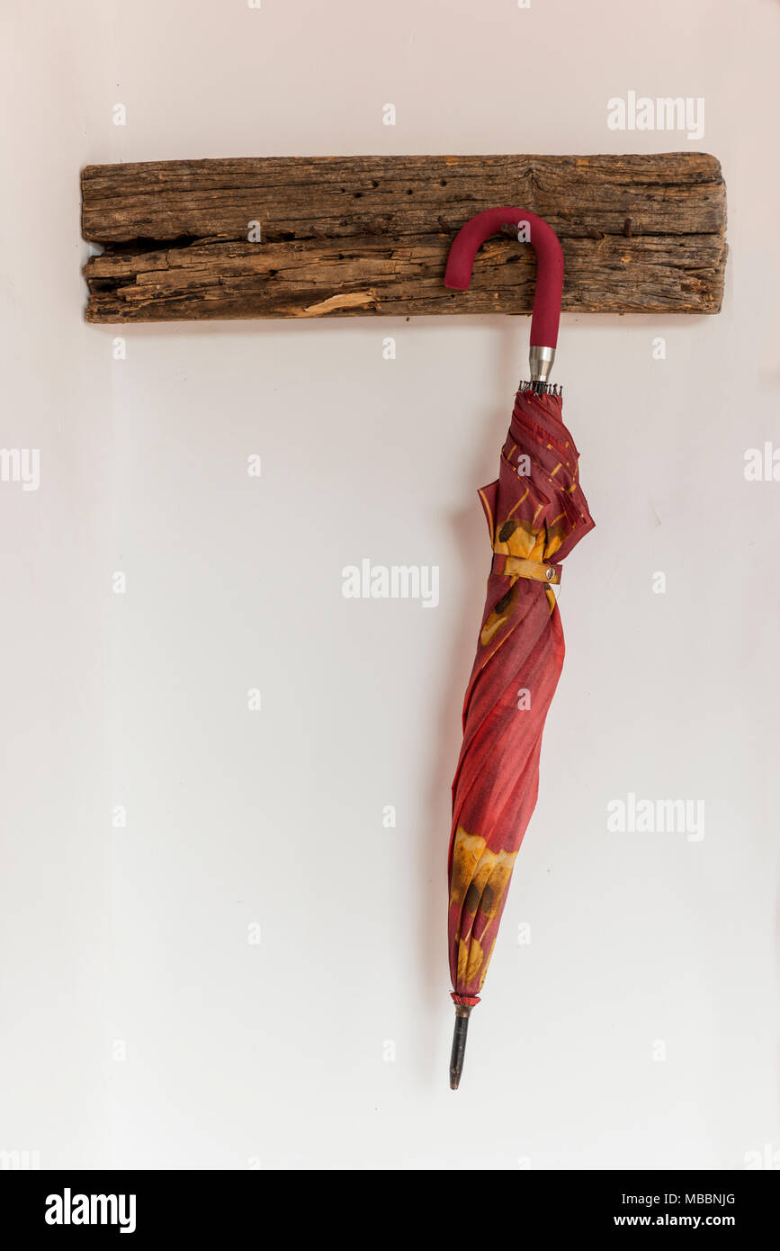 Paraguas amarillo y rojo, cerrado, colgados de un perchero de madera sobre  una pared blanca Fotografía de stock - Alamy
