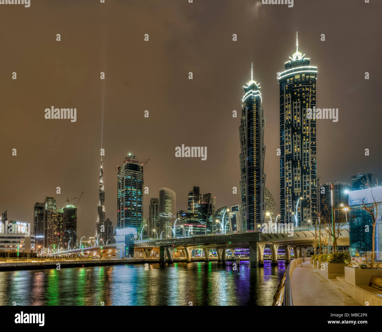 Una vista de los edificios altos en el área de la Bahía de Negocios iluminada por la noche en Dubai, EAU, del Oriente Medio. Foto de stock