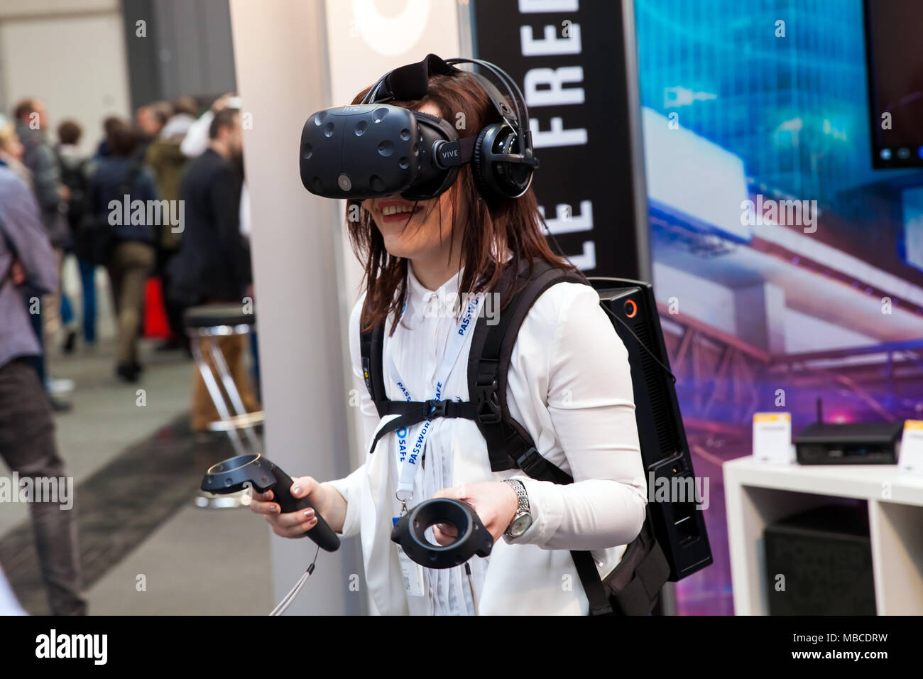 Niña jugando juegos de video en el casco de realidad virtual y los controladores de dispositivo desarrollado por HTC vive en la exposición Cebit 2017 en Hannover, Alemania Foto de stock