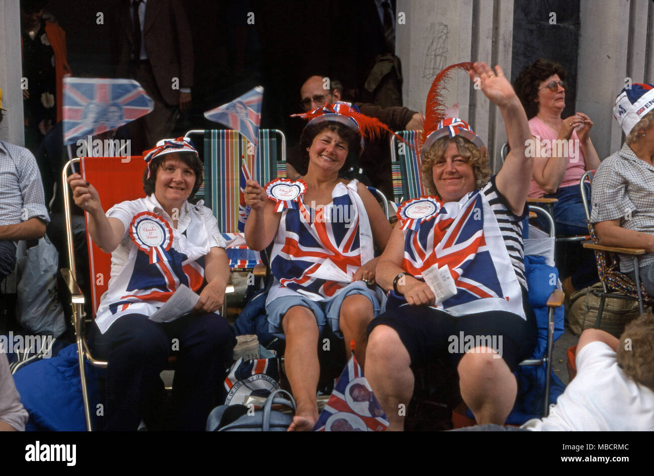 Las mujeres fuera sentados en sillas de cubierta en el Strand durante la celebración en Londres de la Princesa Diana y el Príncipe Carlos boda Foto de stock