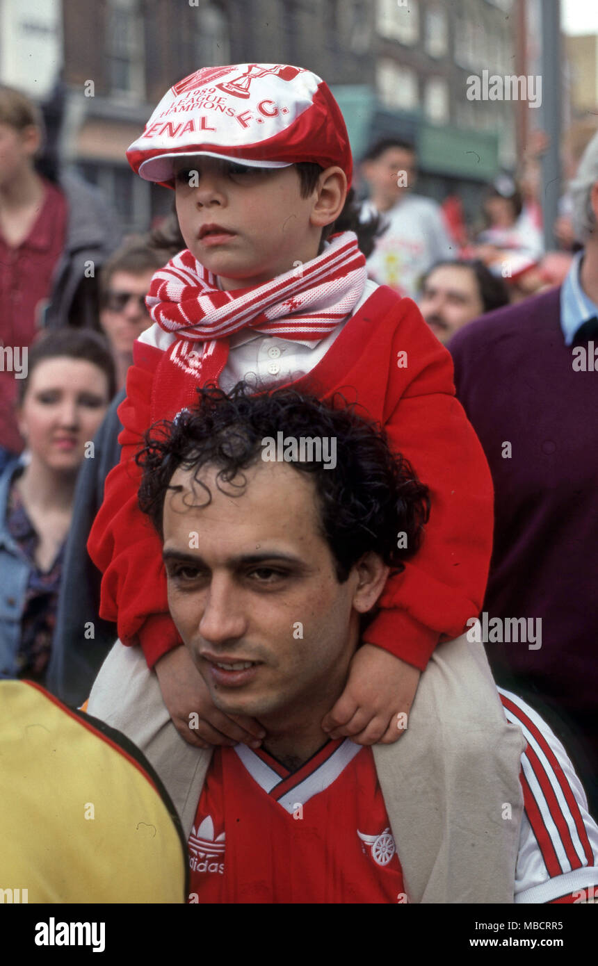 Los seguidores del Arsenal, padre e hijo, después del partido de fútbol vistiendo los colores del equipo Foto de stock