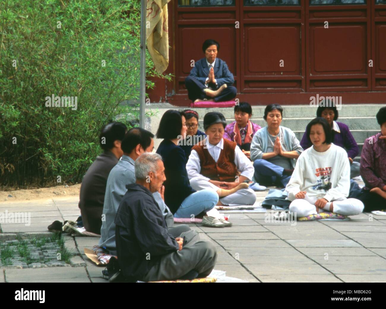 Grupo de meditación fuera de un templo en el Bei Hai Jardines, Beijing, China. Foto de stock