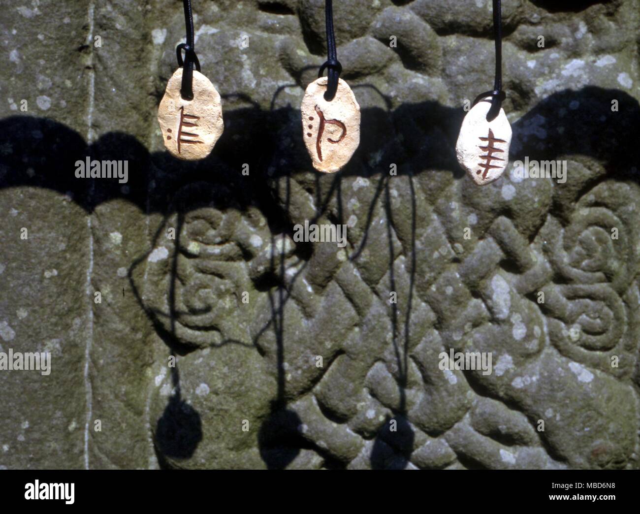 Alfabetos - Piedras Ogham - piedras Ogham céltico (de izquierda a derecha) de febrero (Sauce ), la Tierra (hayas, la Phagos) y agua (Álamo ). Colgando cerca del zócalo de la Cruz del Sur en Monasterboice, Irlanda. Ogham - es la primera forma de escritura en Irlanda, se remonta a alrededor del siglo III D.C. y estuvo en uso durante unos 500 años. El alfabeto ogham se compone de una serie de trazos a lo largo o a través de una línea. El alfabeto fue tallada en piedras para conmemorar a alguien, con el borde de la piedra como la línea central. Normalmente se lee desde el lado izquierdo de abajo a arriba, en la parte superior un Foto de stock