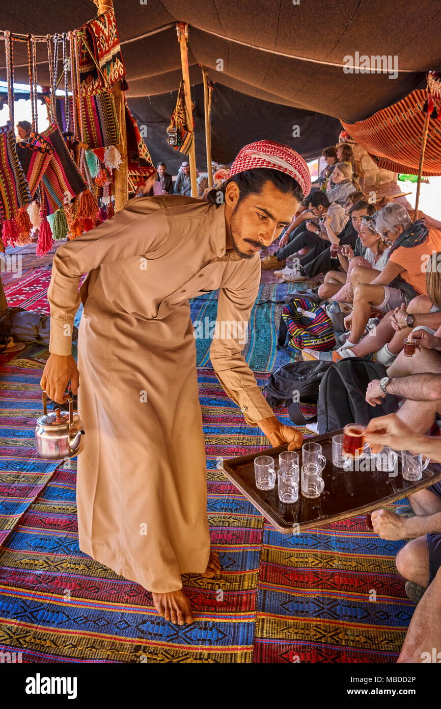 Joven beduino que sirve té a los turistas, el desierto de Wadi Rum, Jordania Foto de stock