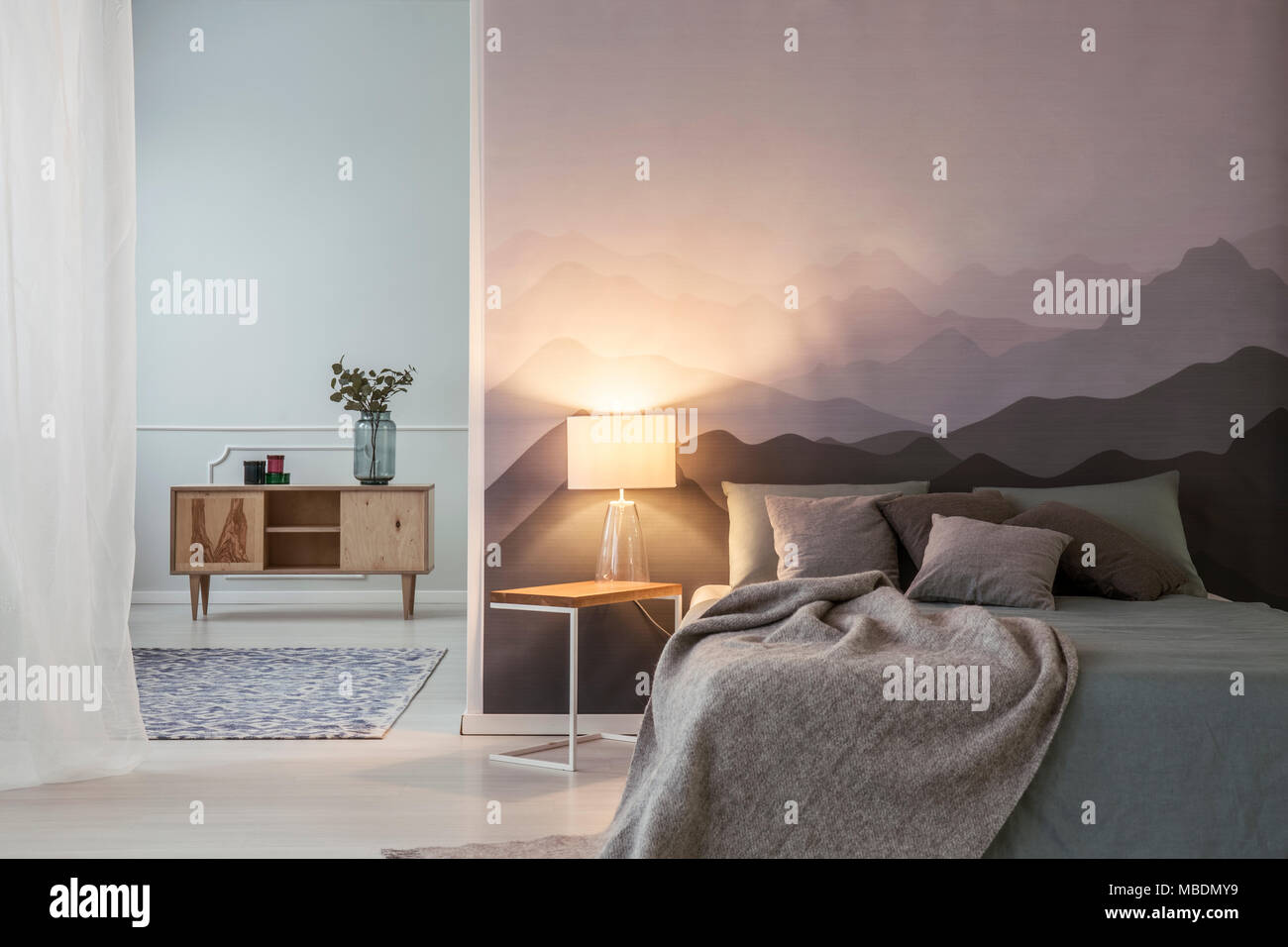 Luz gris junto a la cama en un dormitorio espacioso interior con armario de  madera Fotografía de stock - Alamy