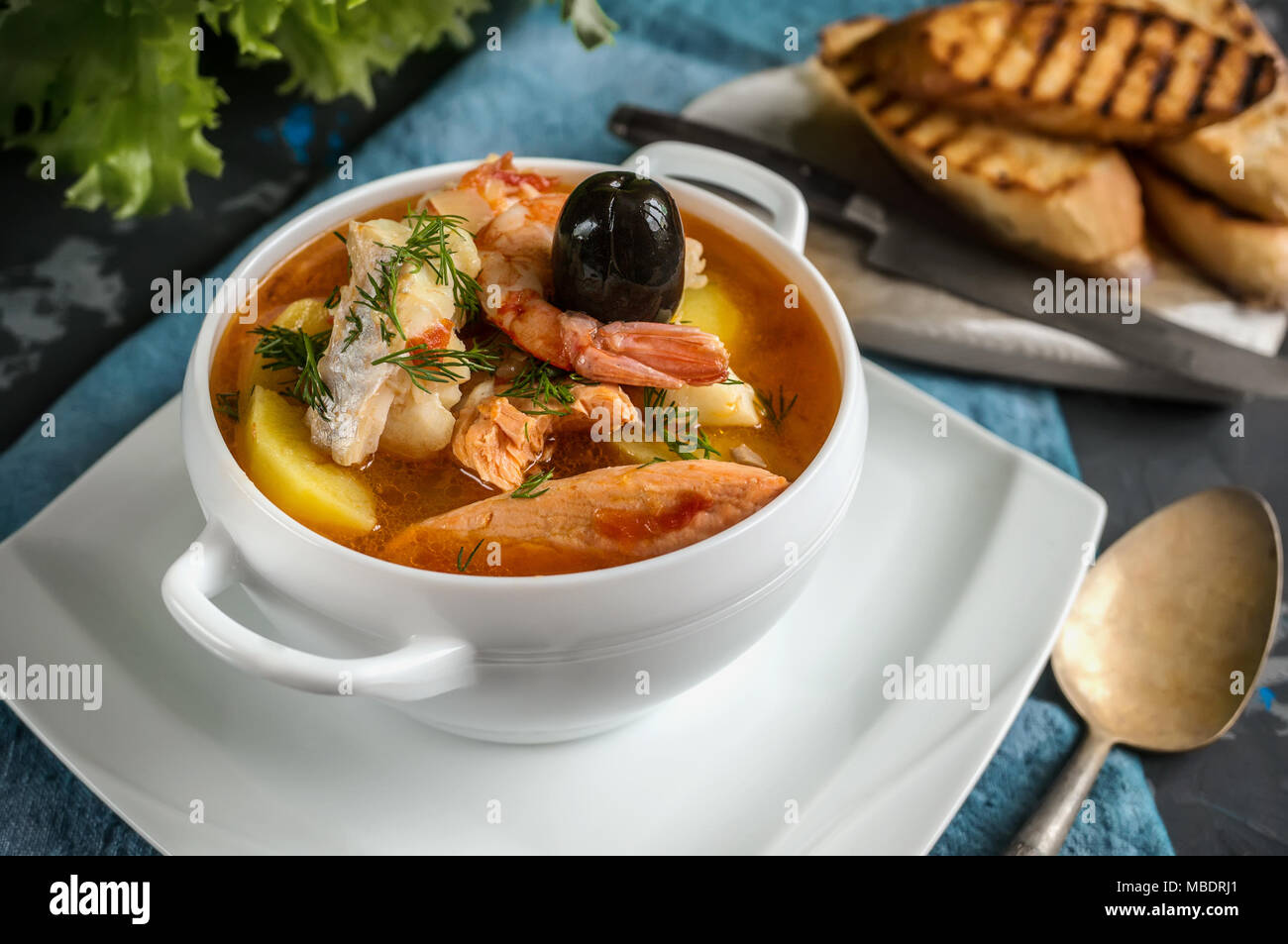 Sopa de pescado francesa Bouillabaisse de mariscos, filete de salmón,  gambas, rico sabor, deliciosa cena en una hermosa placa blanca. Cerca  Fotografía de stock - Alamy