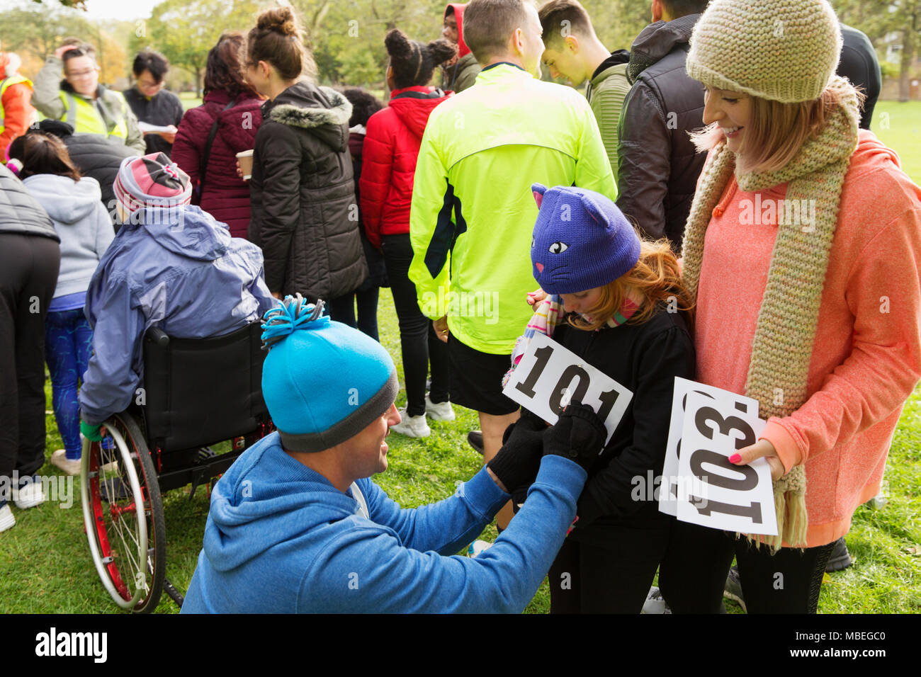 Padre corredor de maratón pinning de bib en la hija de la caridad se ejecutan en park Foto de stock