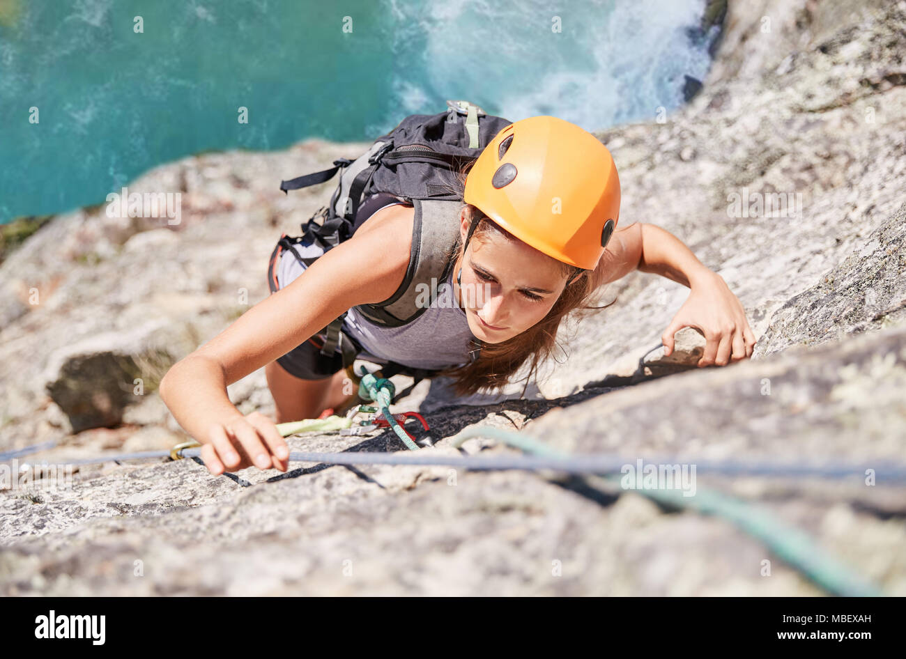 Enfocada, decidida mujer escalador escalar roca Foto de stock