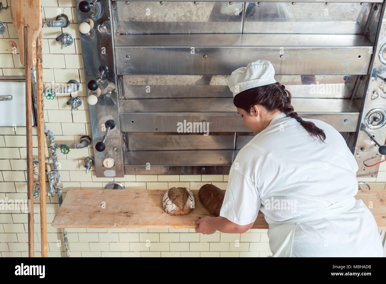 Baker mujer obteniendo rebanadas de pan de horno de panadería Foto de stock