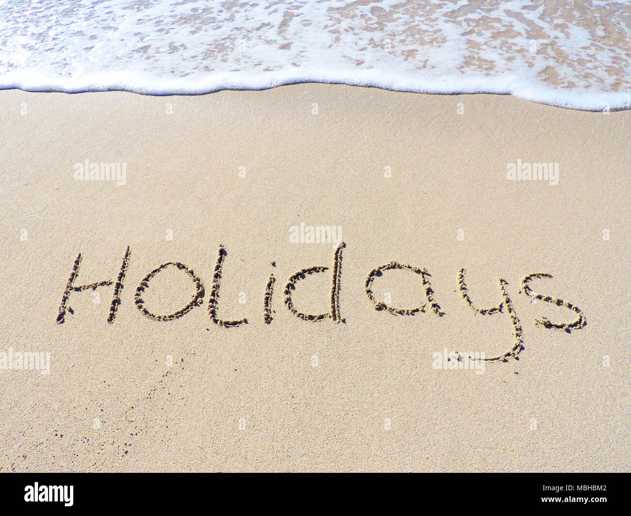 Vacaciones dibujo o texto en la arena. Escena de playa, vacaciones de verano. Foto de stock