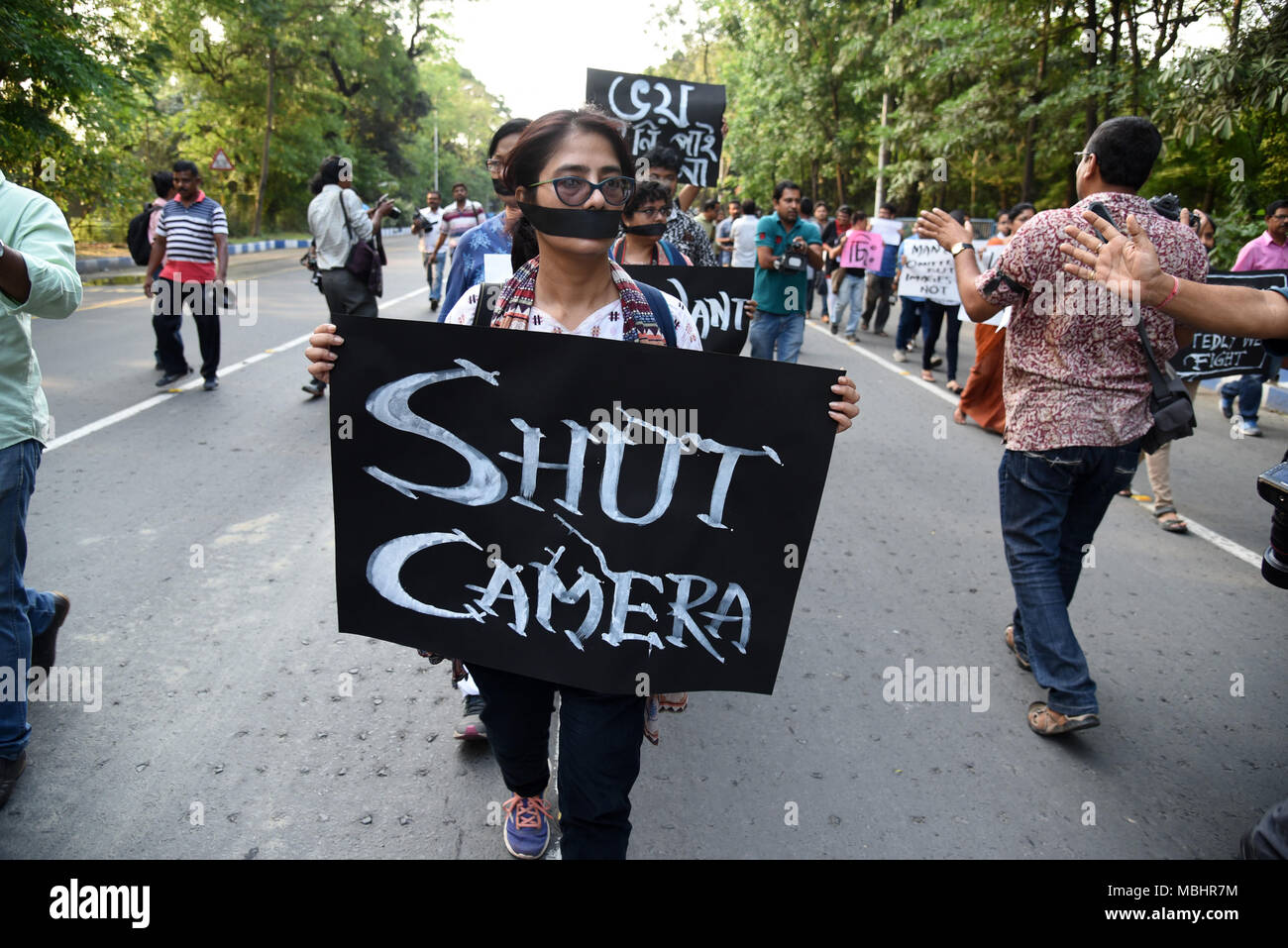 En Kolkata, Bengala Occidental, India. 11 abr, 2018. Ve a una mujer sosteniendo un cartel durante la protesta.Cientos de periodistas protestan contra el presunto ataque del partido gobernante sobre los periodistas a través de bengala durante la nominación de Panchayat cobertura. El rallye empezó en mayo calle Mahatma Gandhi estatua .y culminó en Dorina cruzando en Kolkata. Usando bandas negras en los brazos y cubra su boca con negro bufandas, ciudad de cientos de periodistas, camarógrafos y fotógrafos participaron en la manifestación de protesta. Crédito: Zuma Press, Inc./Alamy Live News Foto de stock