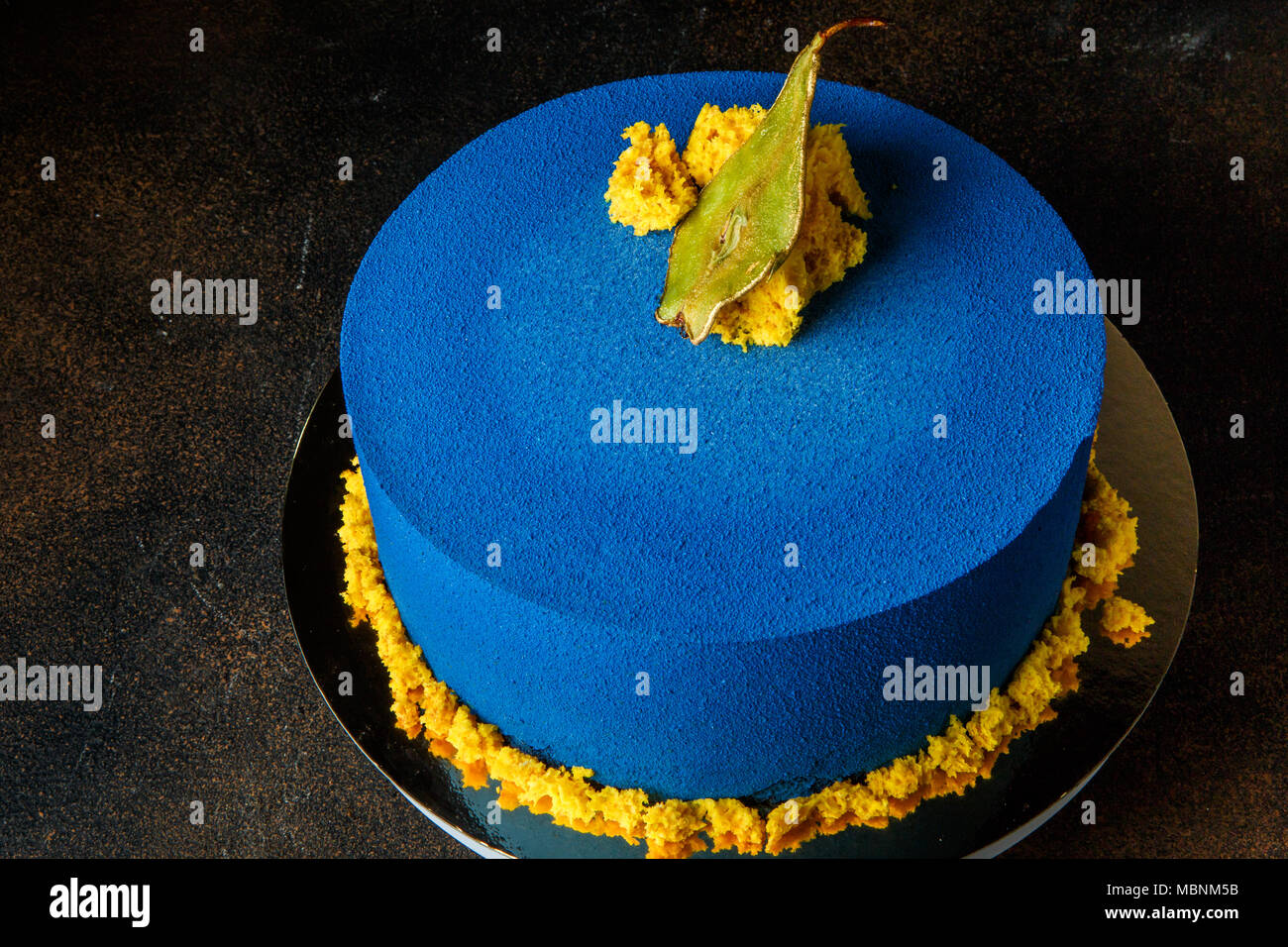 Delicioso pastel redondo azul decorado con pera secos y trozos de bizcocho  amarillo vista superior Fotografía de stock - Alamy