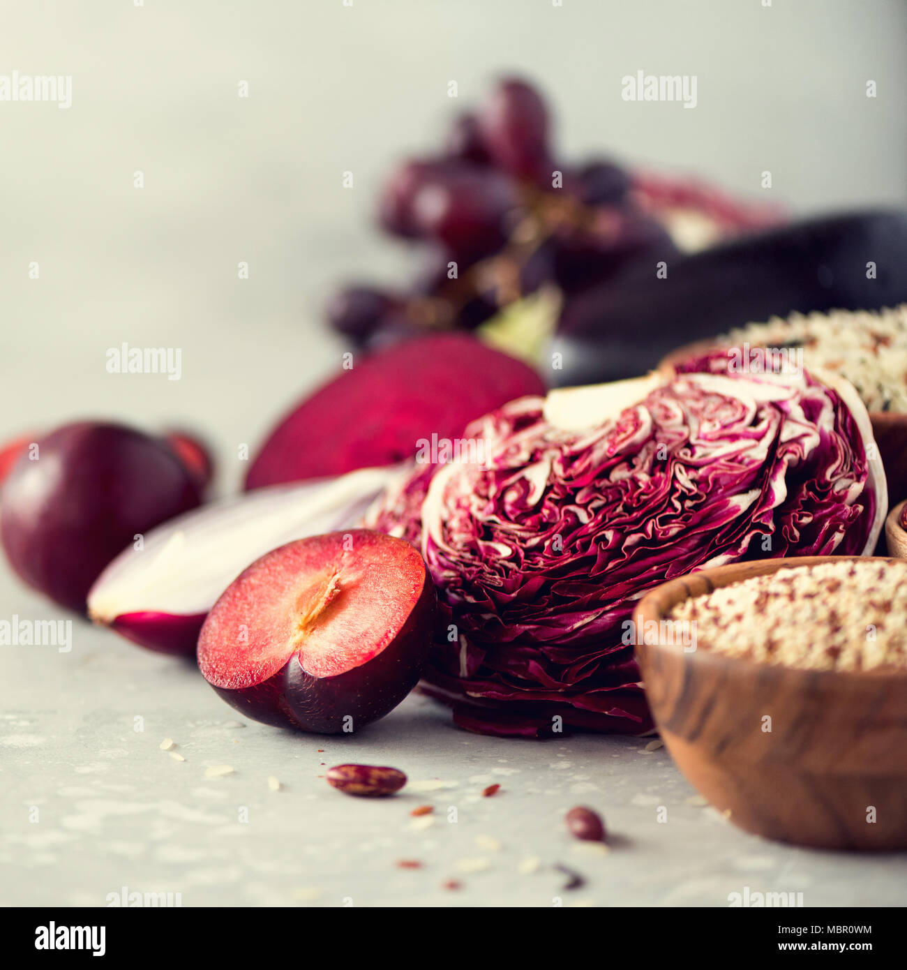 Ingredientes para cocinar, copie el espacio, vista superior, plano laical. Las verduras, las frutas púrpura sobre fondo gris. Violeta berenjena, remolacha, coliflor, violeta, frijoles, ciruelas, cebolla, uva, quinoa, arroz. Foto de stock