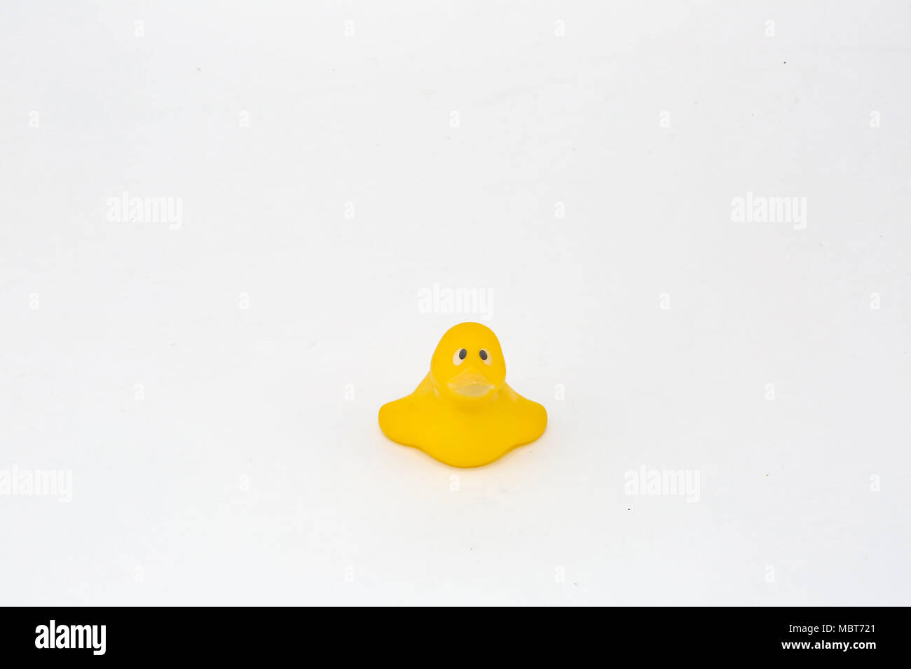 Un pato de juguete de plástico amarillo con ojos implorantes. El tipo de pato de plástico que pondría en un baño. La expresión evoca un sentimiento de simpatía. Foto de stock