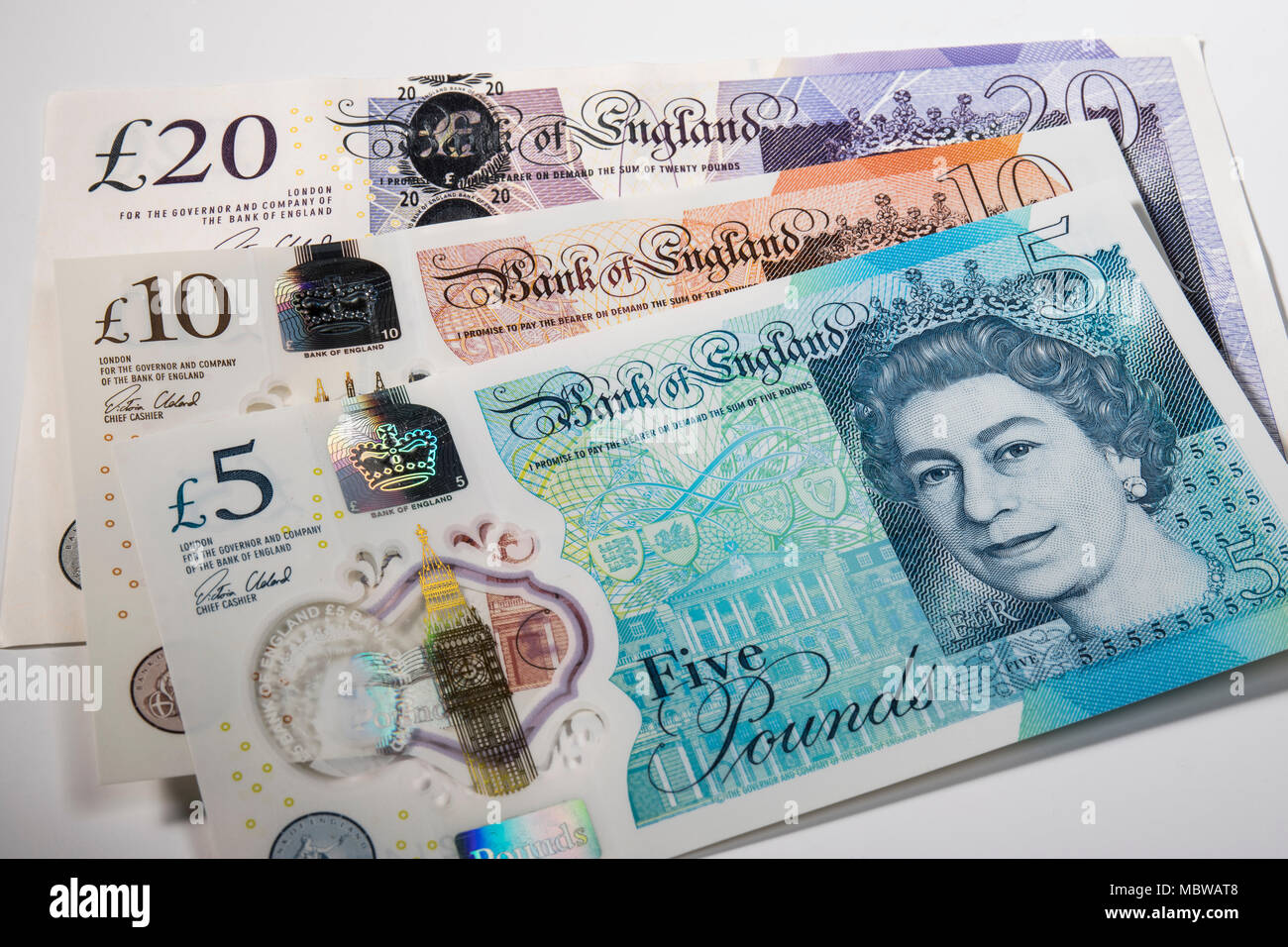 £1 monedas colocados al azar en Reino Unido £5, £10 y £20 notas Foto de stock