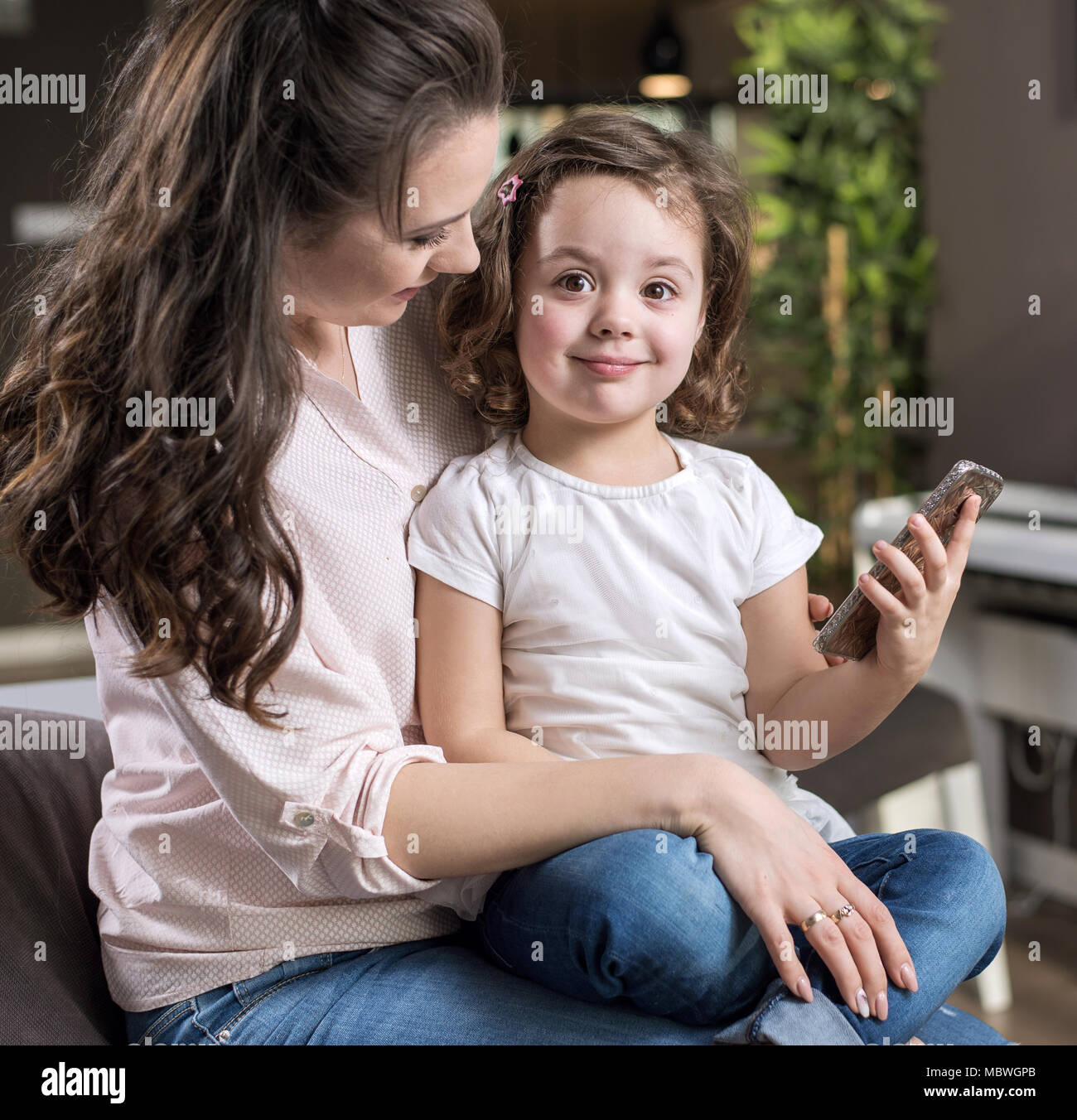 Feliz madre con una linda hija en casa Foto de stock