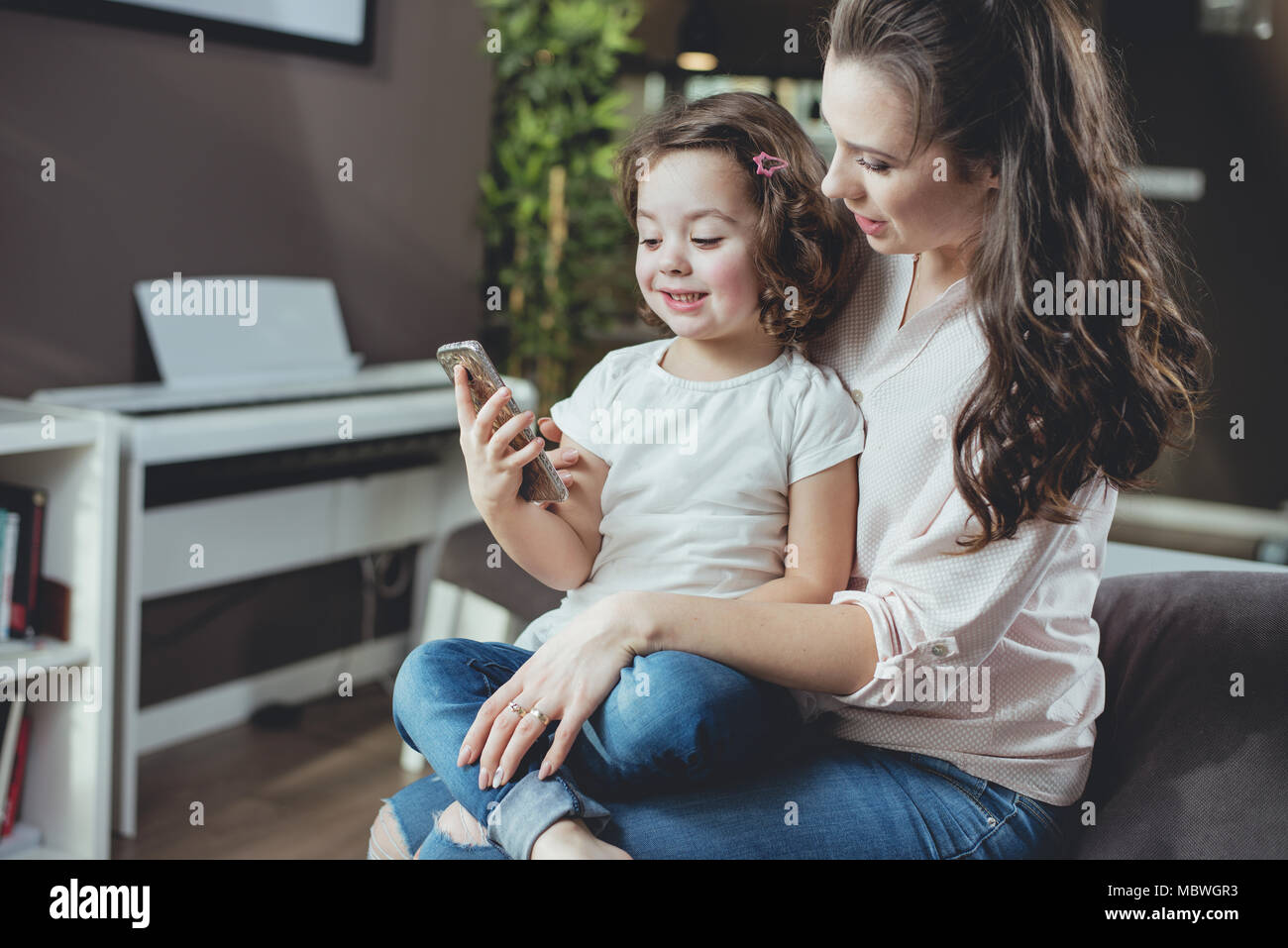 Feliz madre con una linda hija en casa Foto de stock