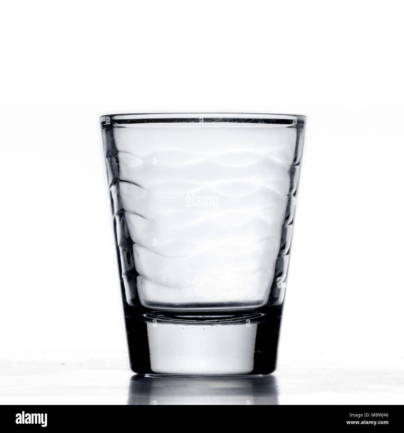 Vaso pequeño alcohol shot cup, que se llena con agua azul, o líquido,  primer plano, fondo blanco con reflejo Fotografía de stock - Alamy