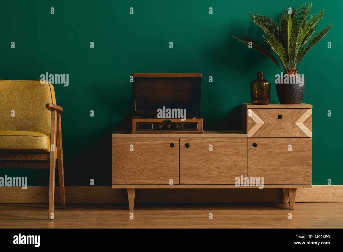 Close-up de un retro aparador de madera con un hipster tocadiscos en un  ambiente minimalista verde oscuro salón interior Fotografía de stock - Alamy