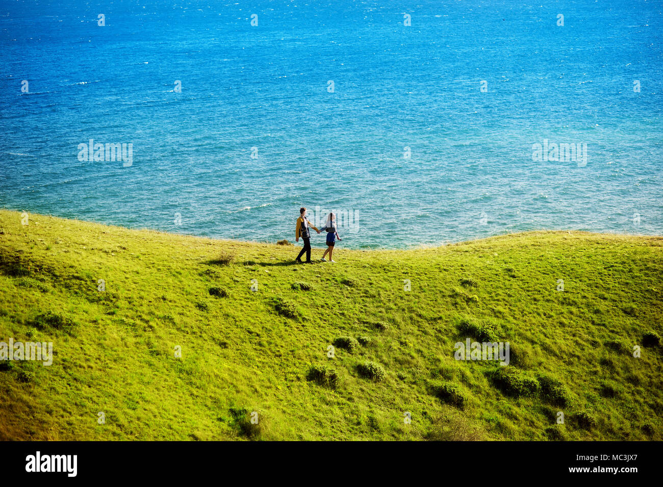 Una joven pareja amorosa en el fondo de un hermoso paisaje, el mar y la montaña. Foto de stock