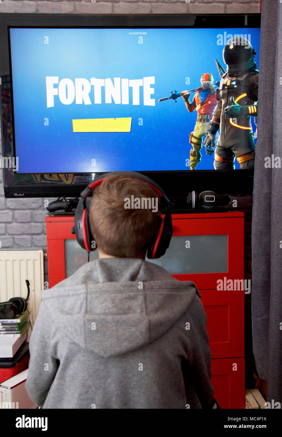 Un niño juega Fortnite Battle Royale en su Xbox 1 Foto de stock