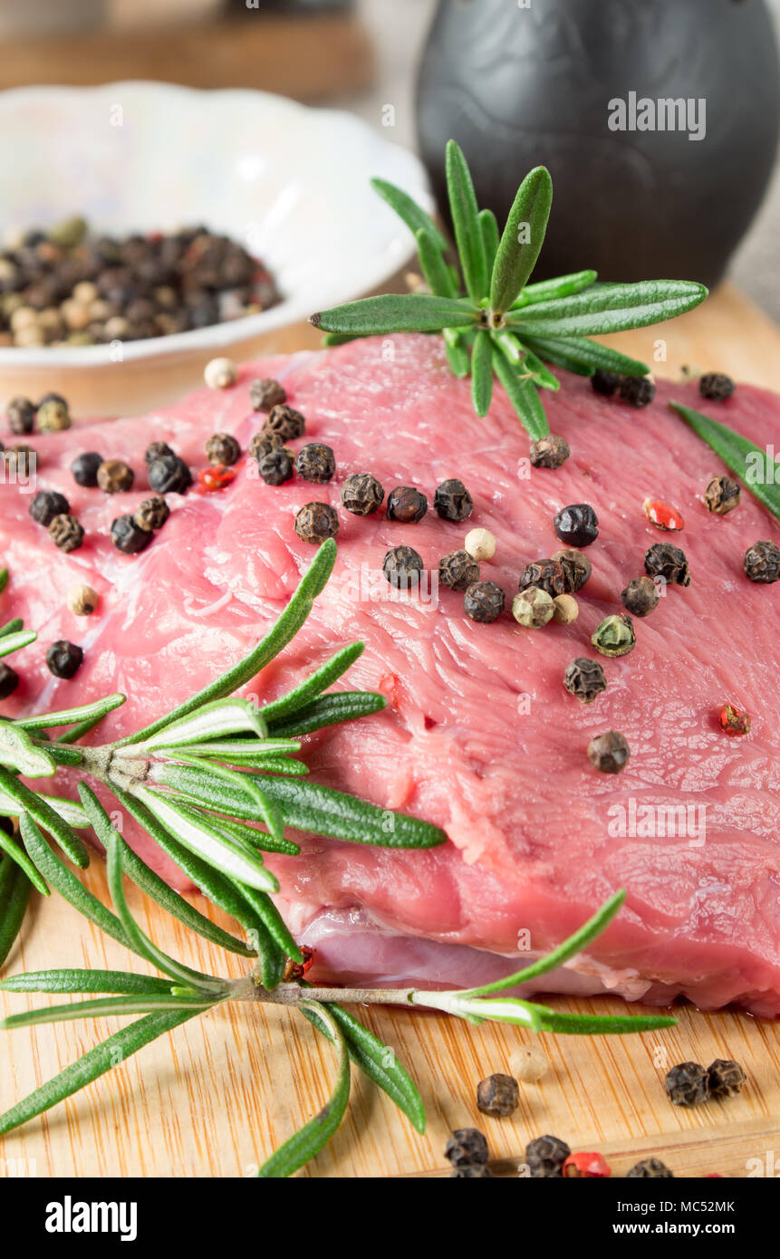 Solomillo de ternera cruda con hierbas y especias en la cocina para cocinar los platos de carne con poca profundidad de enfoque. Foto de stock