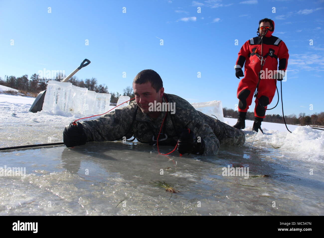 Un soldado participa en la formación de inmersión de agua fría un cubiertas de hielo del gran lago de arena bajo la atenta mirada del instructor Bill Hamilton como parte de