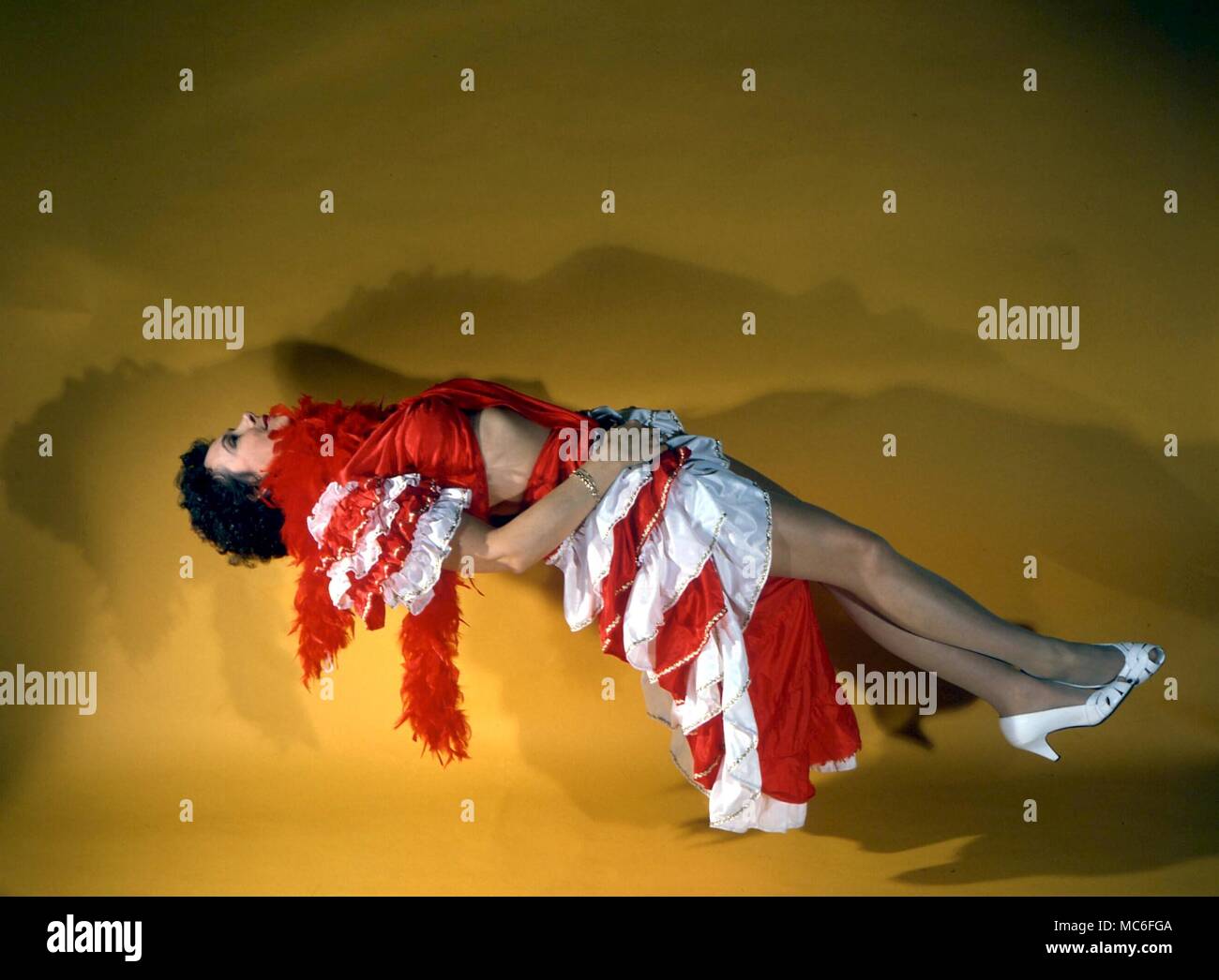 Levitación, magia en el escenario, la ilusión. Mujer aparentemente flotando en el aire. Foto de stock