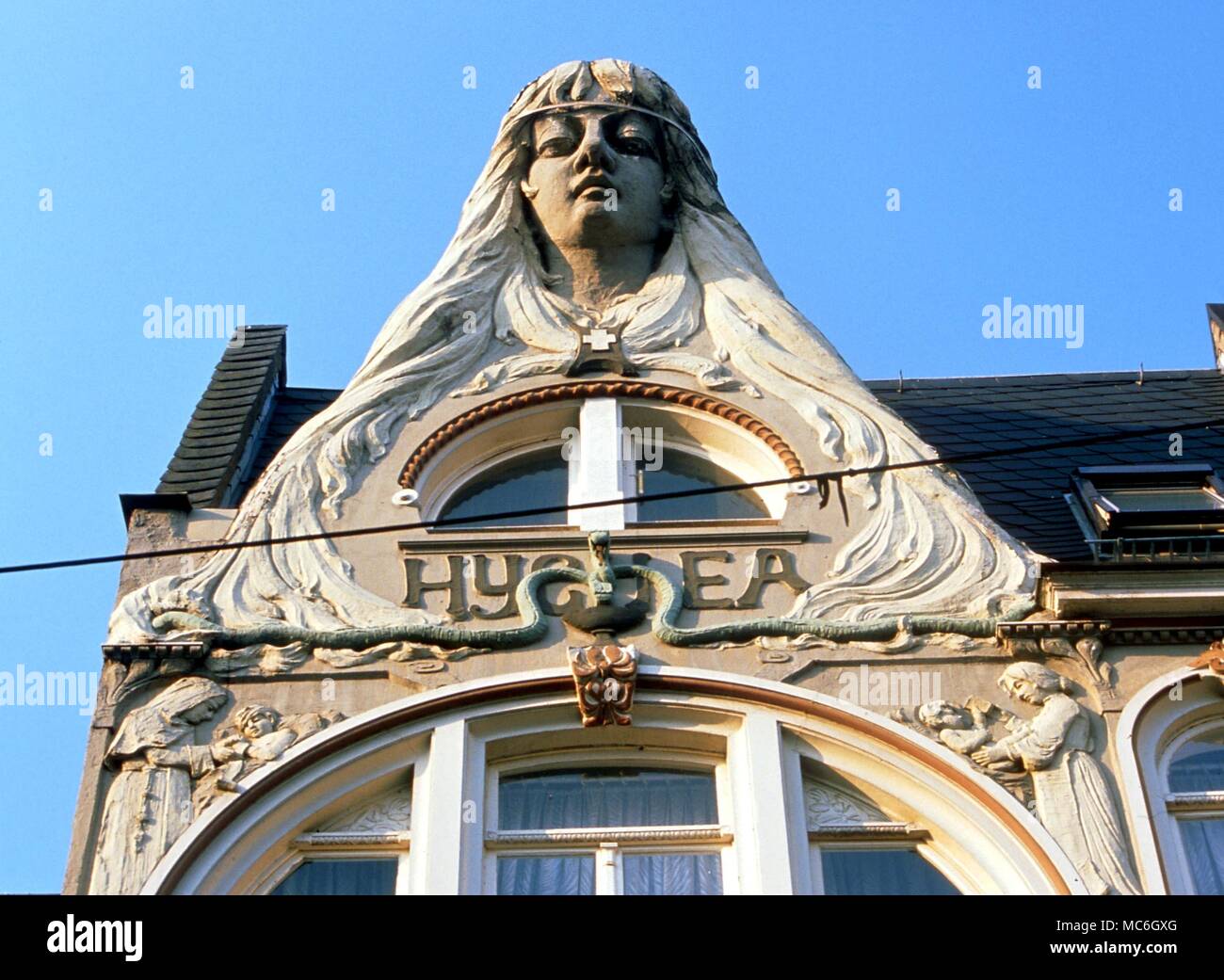 Medicina - una enorme cabeza de Higía, diosa griega de la salud, adorado como un aspecto femenino de Asciepius (en el culto Orféicas, ella era su esposa). Esta estatua se alza sobre la fachada de una antigua farmacia en Koblenz Foto de stock