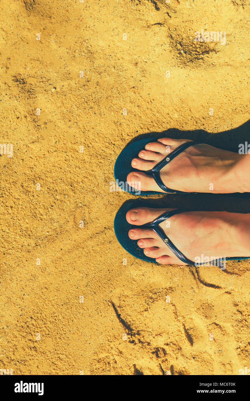 Mujer de piernas en zapatillas sobre fondo de arena amarilla. Chanclas de  playa azul. Copie el espacio, vista desde arriba. Concepto de viajes y  vacaciones Fotografía de stock - Alamy