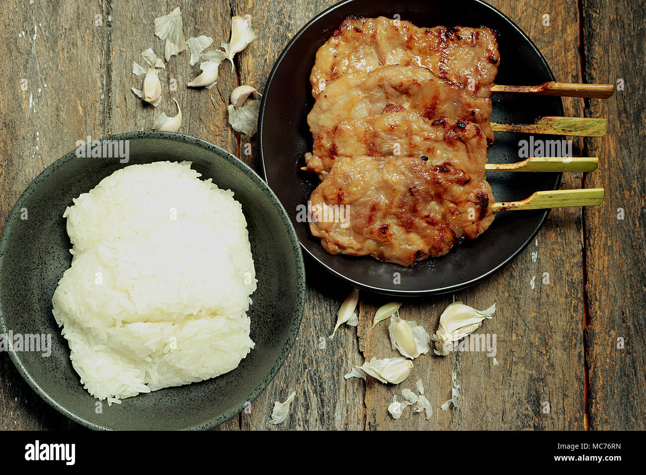 En esta imagen, hay arroz pegajoso, asado de cerdo. El ajo es un componente. Foto de stock