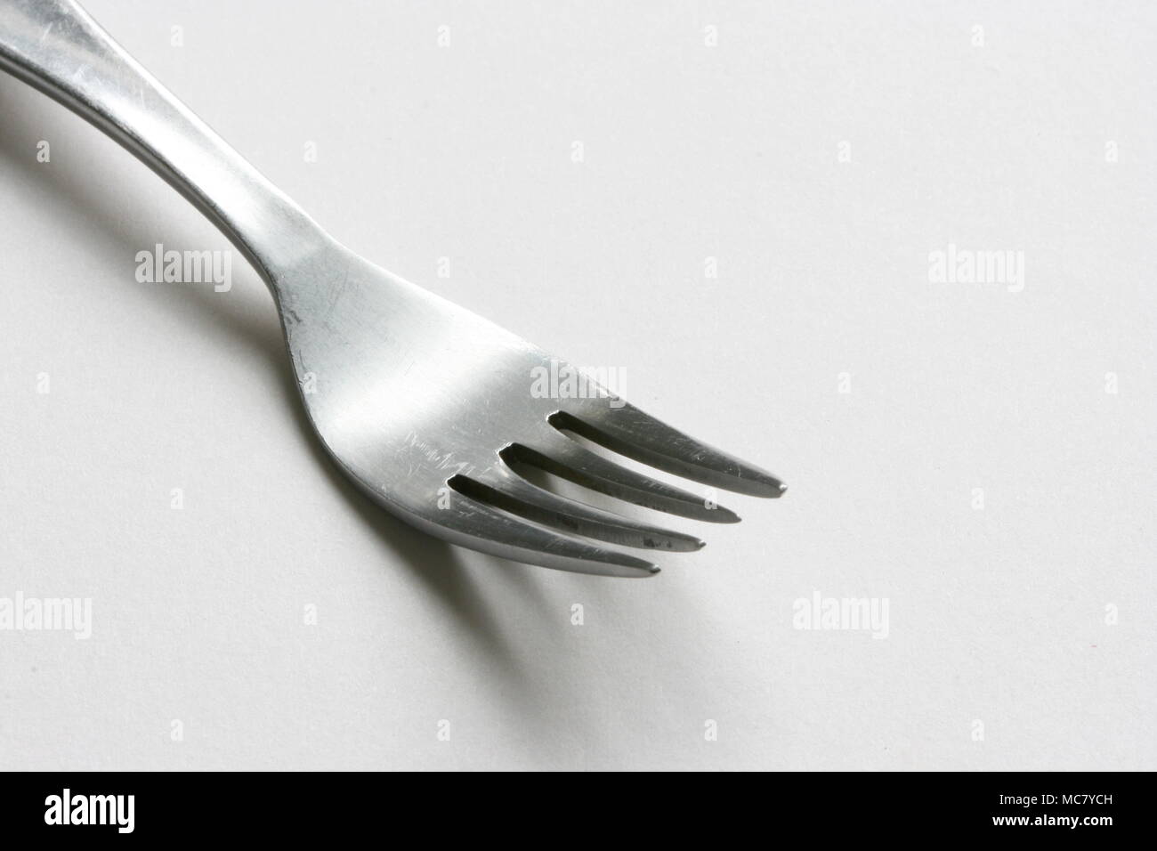 Tenedor de cocina sobre un fondo liso. Foto de stock