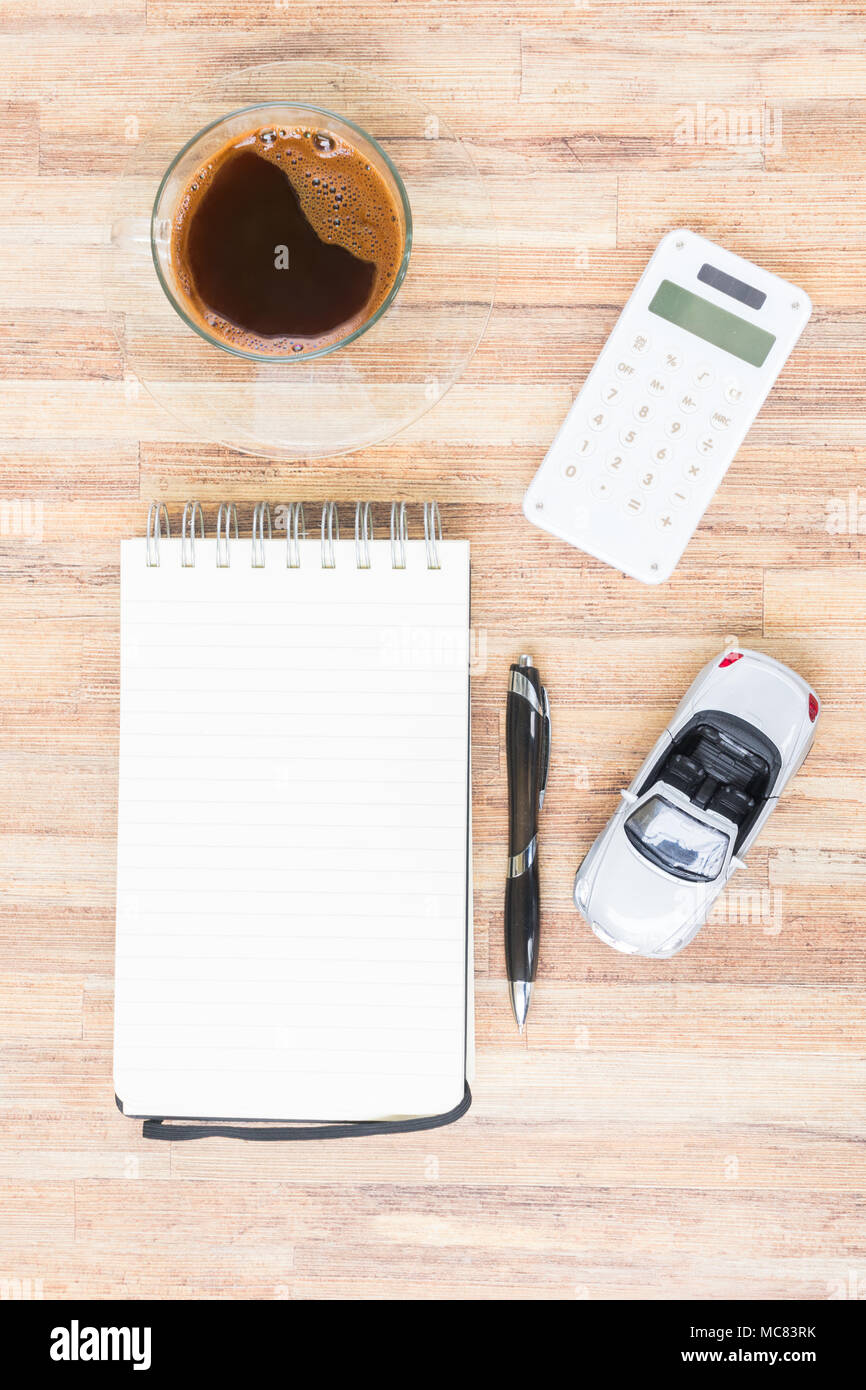 Juguete coche gris con bloc de notas, calculadora y el café en la mesa de  madera Fotografía de stock - Alamy