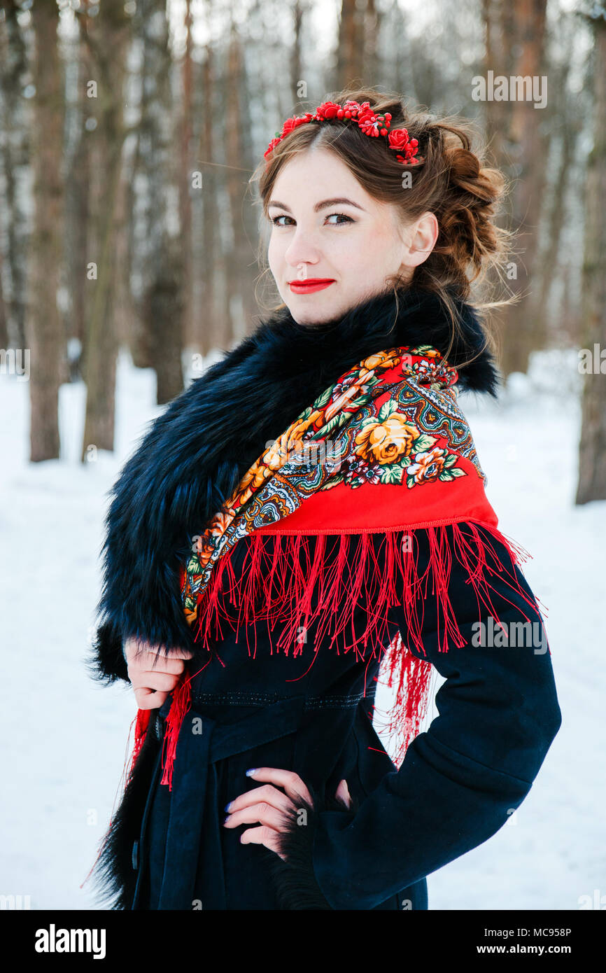Invierno portreit chica sonriente con un cabello hermoso en su cabeza en  ruso estilo folk de pañuelos rojos Fotografía de stock - Alamy