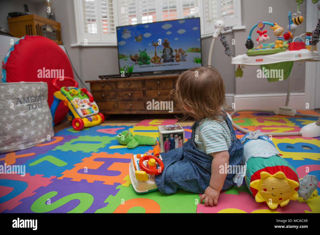 bebé de 10 meses sentado viendo la televisión solo Fotografía de stock -  Alamy