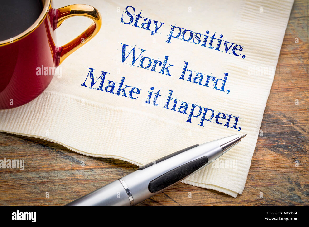 Mantener una actitud positiva. Trabajar duro. Hacer que suceda. Inspirador de la escritura a mano en una servilleta. Foto de stock