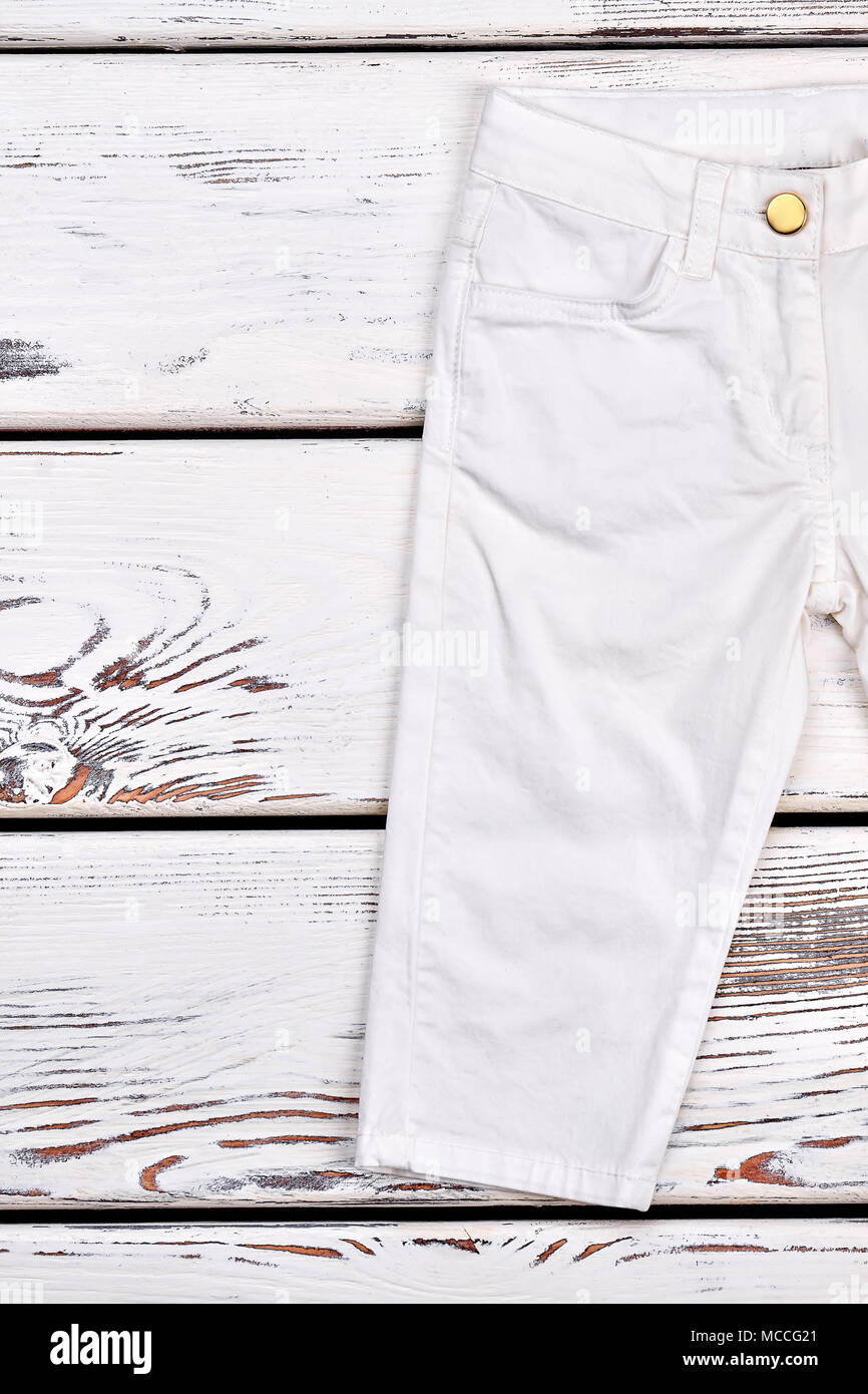 Los niños blancos pantalones de moda. Niño chico blanco pantalón moderno en  madera de fondo, imagen recortada Fotografía de stock - Alamy