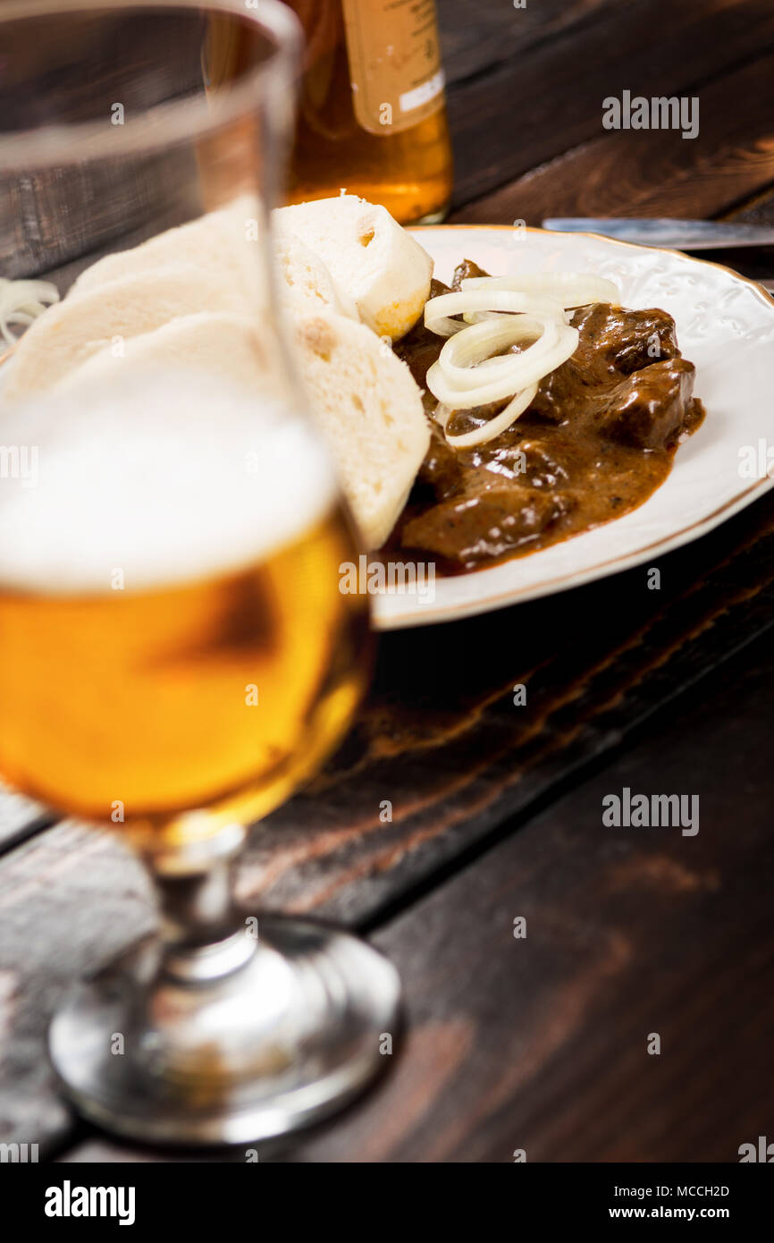 Checa tradicional goulash con bolas de masa de harina y cerveza en el cuadro oscuro Foto de stock