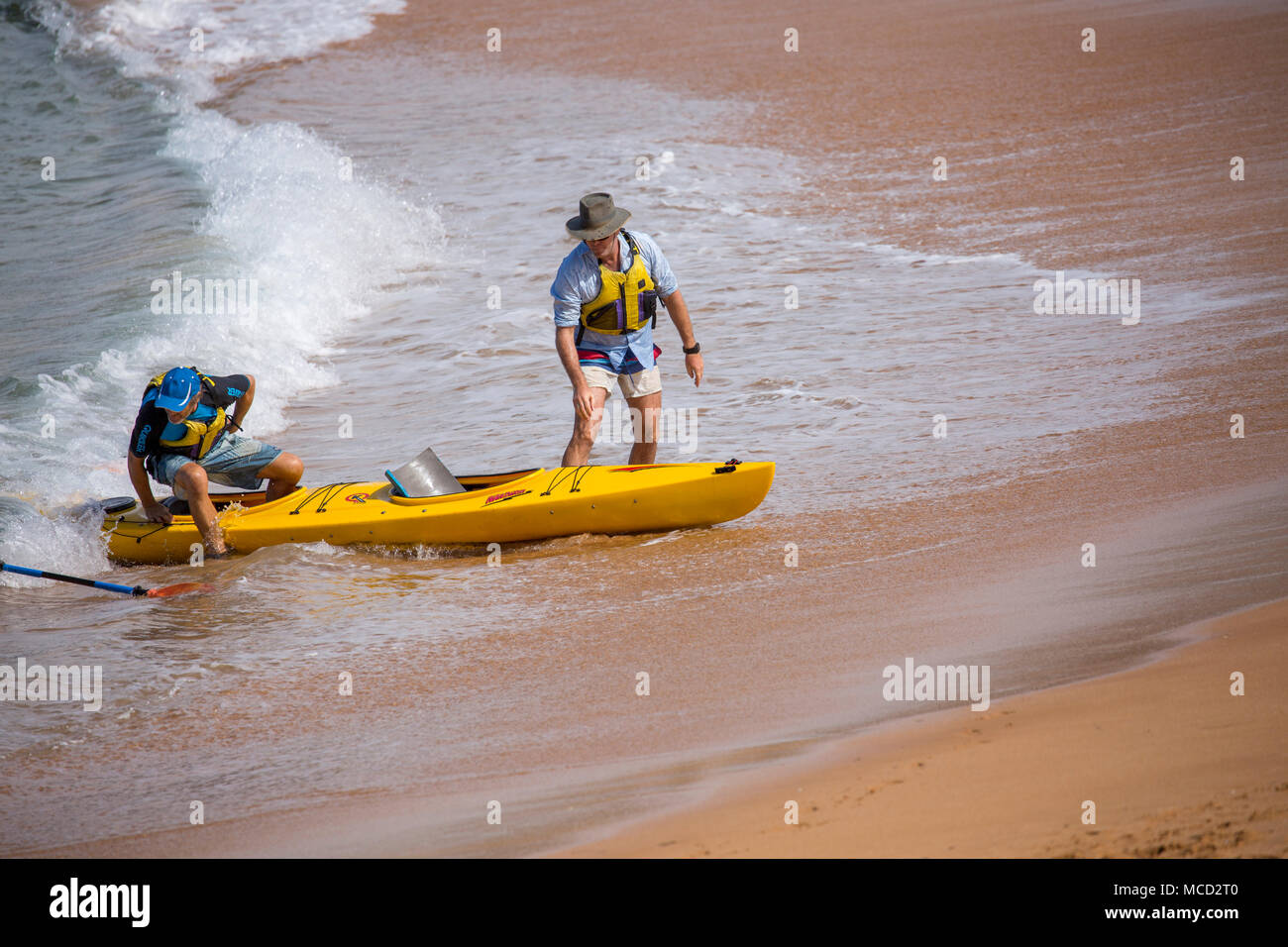 Dos hombres con su barco ocean kayak de mar en la playa de Avalon en Sydney, Australia Foto de stock